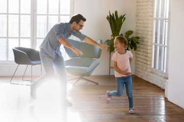 Sticker - Overjoyed young father have fun engaged in funny activity with small preschooler daughter at home, happy dad chasing catching excited little girl child, play tag and touch game together on weekend