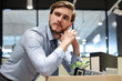 © ty - Sad dismissed worker are taking his office supplies with him from office.