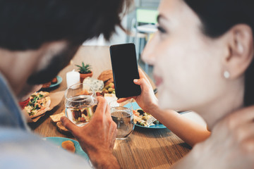 Romantic family couple have dinner at home with lots of food on the table, sharing pictures with social network