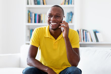 Laughing African American Mature Adult Man In Quarantine Talking At Mobile Phone