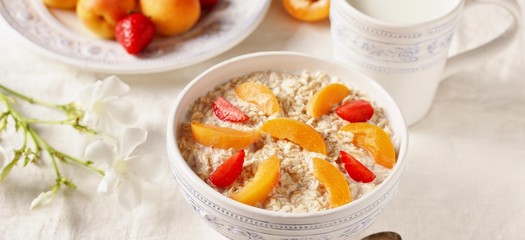 Sticker - breakfast with oatmeal and fruit, apricot and strawberries with milk. Summer season, fresh fruits, copy space