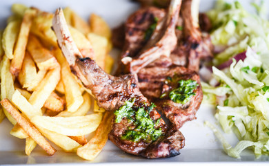 Wall Mural - delicious grilled lamb chopsticks with french fries, pesto sauce & mix of lettuces