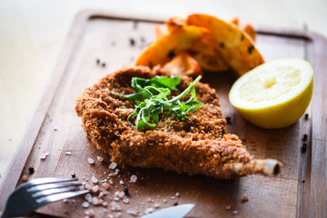 Wall Mural - delicious crispy panko pork schnitzel with wedges & fresh pepper