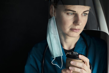 Sticker - tired medical worker doctor holding a paper cup of coffee after taking a large number of patients due to the epidemic of coronavirus