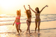 © CandyRetriever  - Silhouette group of happy young beautiful Asian women in bikini swimwear playing and jumping together on tropical beach at sunset. Three sexy girls friends having fun in summer holiday vacation travel