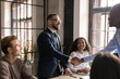 © fizkes - Smiling businessman wearing glasses shaking hands with African American business partner after successful group negotiation, making agreement, legal deal, team leader greeting new member