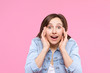 © Monstar Studio - Pretty girl dressed in white t-shirt, denim jacket is standing on pink background. Young surprised woman winner is wondering, having shock. Female gesturing. Emotional portrait concept.