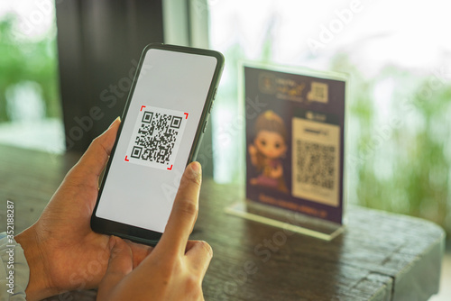 Woman scanning QR code from a label in a shop with mobile phone.