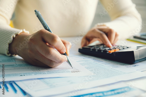 Fotomural Closeup woman filling form of Individual Income Tax Return,