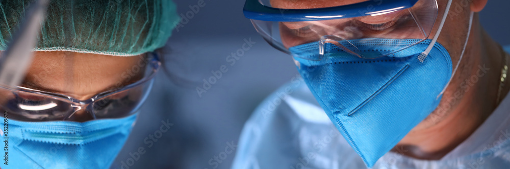 Close-up face of surgeon and assistant at work. - obrazy, fototapety, plakaty 