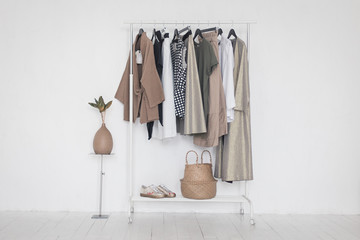 a rack with stylish clothes next to a white wall in the room. clothing retails concept. advertise, s