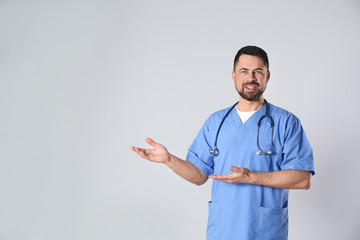 Poster - Portrait of mature doctor against light background