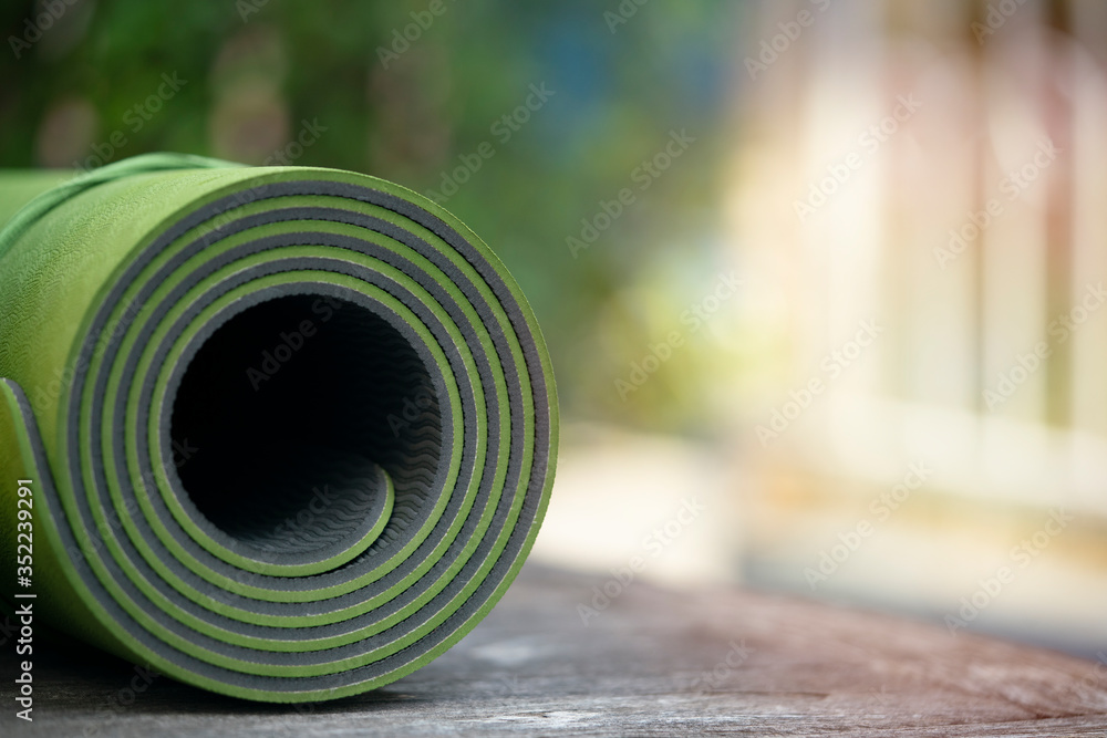 close up of green yoga mat on the table, sport and healthy concept - obrazy, fototapety, plakaty 