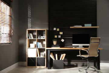 Comfortable workplace with computer and office chair. Stylish room interior