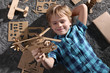 © New Africa - Little boy playing with cardboard helicopter on floor at home, top view. Creative hobby