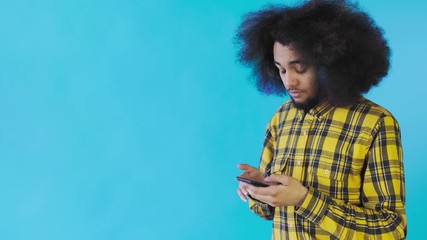 African American man received a new message on his phone on Blue background. Concept of emotions