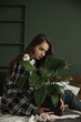 © Maxim - a girl sitting on a bed looking at the camera hugs a flower pot, a girl for the environment, protection of the most expensive, love in the details, a flower like a child