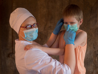 Family with child in mask on gray background. Mother in white coat and baby wear face mask during coronavirus and flu outbreak. .Mother puts her child face protective mask. Coronavirus quarantine