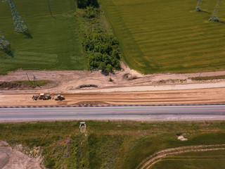 Road Construction Site near the highway with machinery, bulldozer, excavation from above. 4K video, top down view.