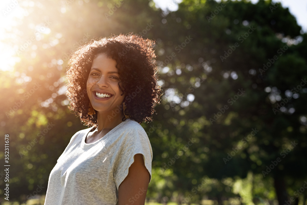 Woman standing in a park in the summer and smiling Stock Photo | Adobe ...