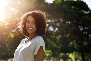 woman standing in a park in the summer and smiling