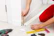 © Angelov - Man putting new skirting board in house