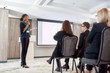 © Svitlana - Innovate, Integrate, Motivate. Full-length shot of female speaker with microphone giving a powerful talk on corporate business meeting
