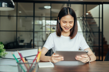 Wall Mural - Young Asian woman hand holding digital tablet on the home.