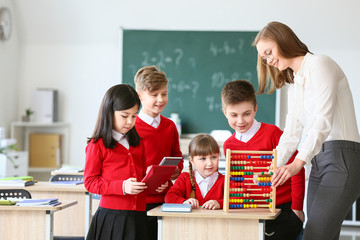 Sticker - Children with math teacher during lesson in classroom