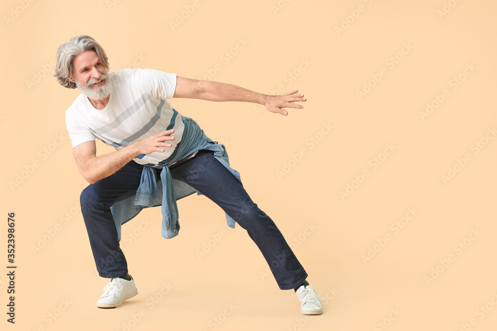 Cool senior man dancing against color background