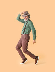 Wall Mural - Cool senior man dancing against color background