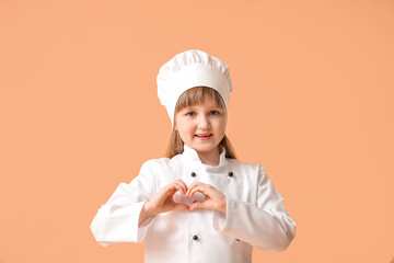 Poster - Cute little chef making heart with her hands on color background