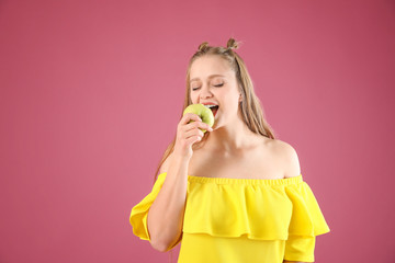 Wall Mural - Young woman with apple on color background. Diet concept