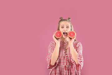 Wall Mural - Surprised young woman with grapefruit on color background. Diet concept