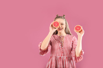 Wall Mural - Young woman with grapefruit on color background. Diet concept