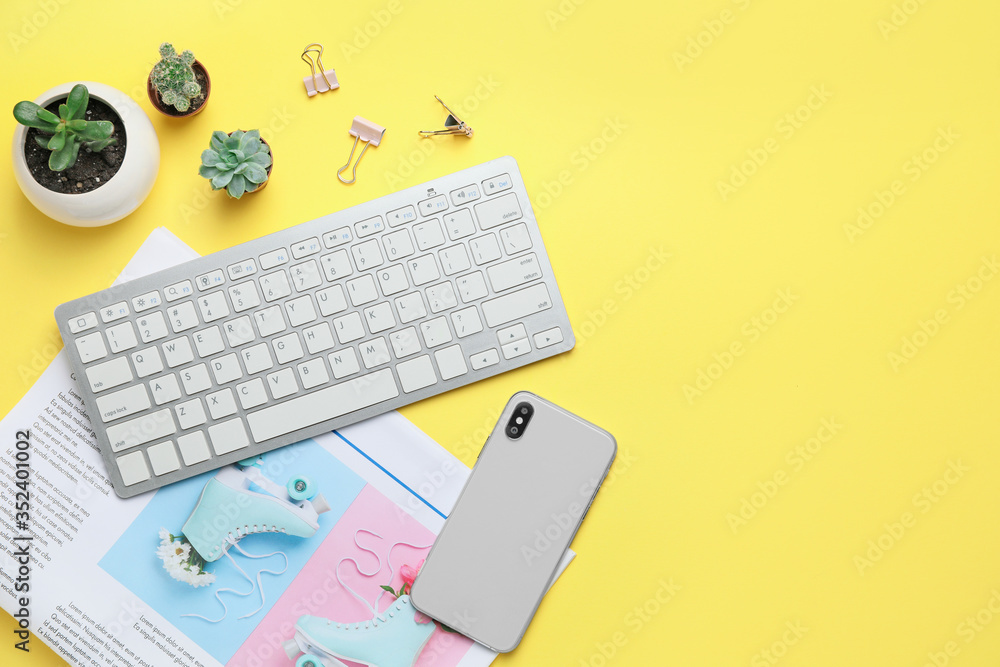 Computer keyboard with newspaper, and mobile phone on color background - obrazy, fototapety, plakaty 