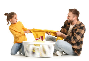 Canvas Print - Happy father and little daughter with laundry on white background