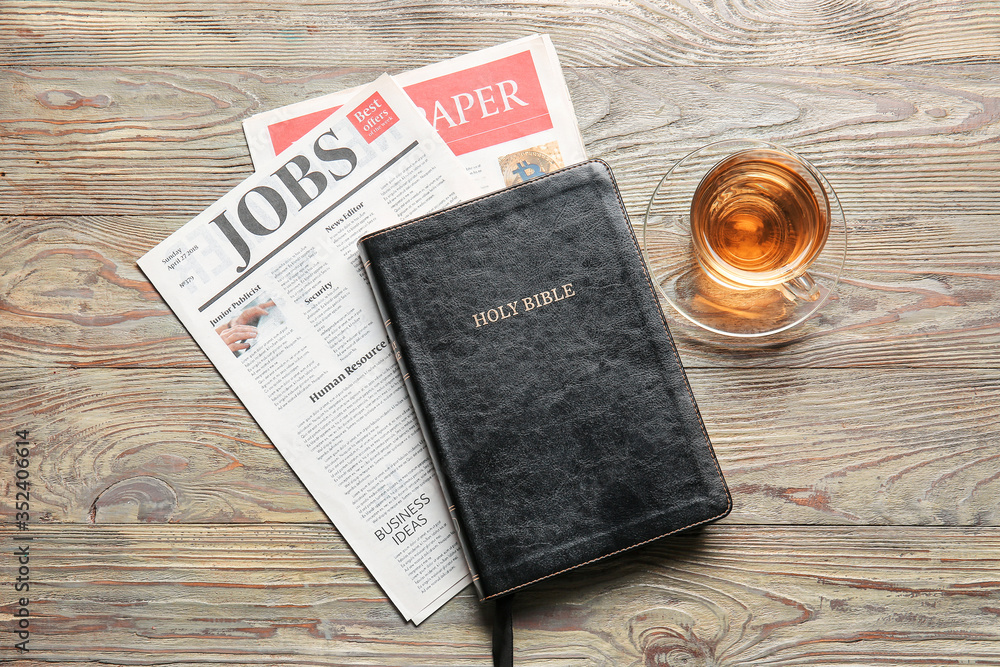 Holy Bible, newspaper and tea on wooden background