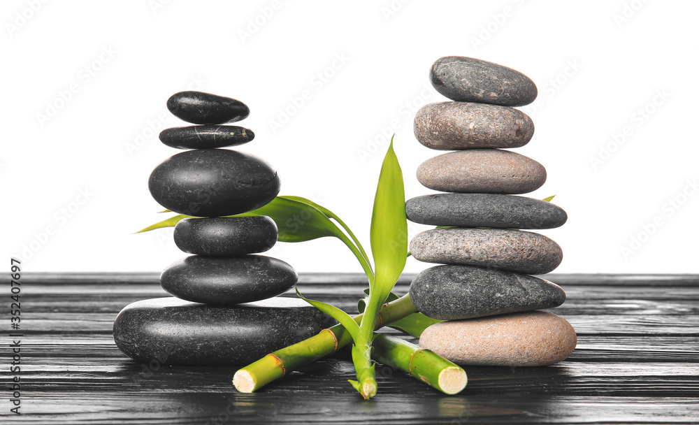 Zen stones and bamboo on table against white background