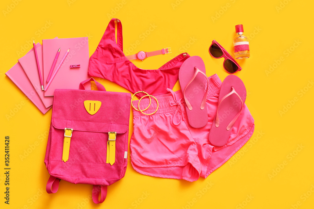 Female accessories and clothes with stationery on color background