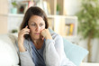 © PheelingsMedia - Pensive middle age woman calling on phone at home