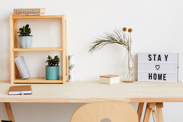 Image of modern table with notepad and flowers on it at home