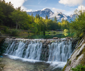 Wall Mural - small waterfall on a stream flowing out of Lake Laghi di Fusine in the Julian Alps in Italy