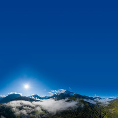 Wall Mural - Panorama of morning sun through green forest mountain with fog and clouds