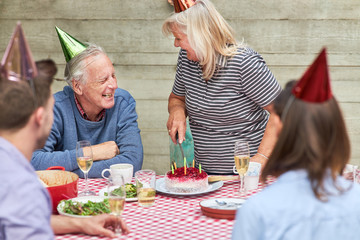 Wall Mural - Senioren feiern mit Familie Geburtstag mit Kuchen