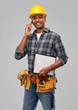 © Syda Productions - profession, construction and building - happy smiling indian worker or builder in helmet with clipboard calling on smartphone over grey background