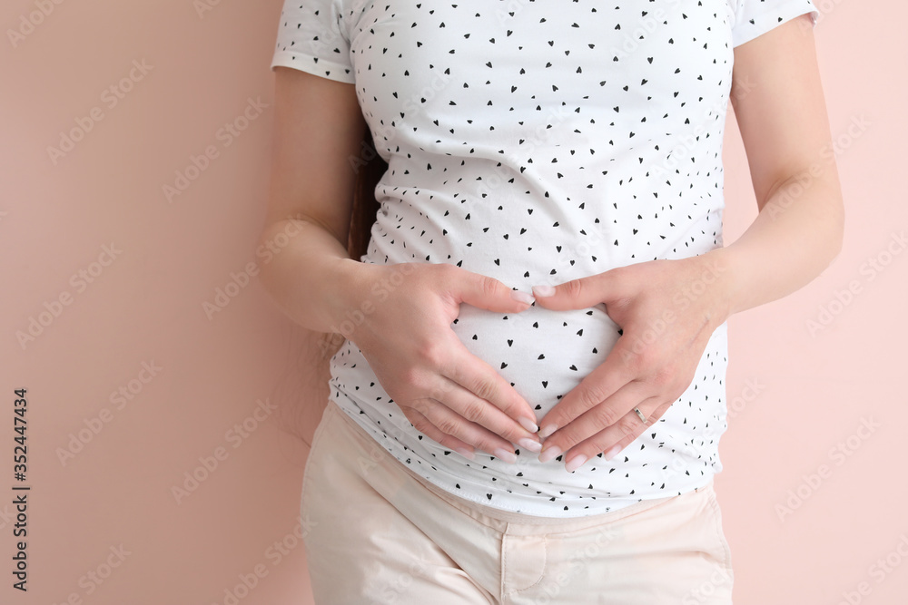 Beautiful pregnant woman on color background