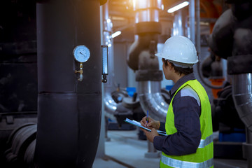 A engineer under checking the industry cooling tower air conditioner is water cooling tower air chiller HVAC of large industrial building to control air system.