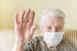 © berna_namoglu - Old woman with health mask making stop sign with wrinkled hand