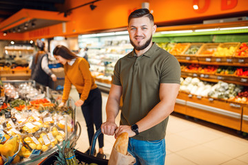 Wall Mural - Couple with basket in grocery supermarket together